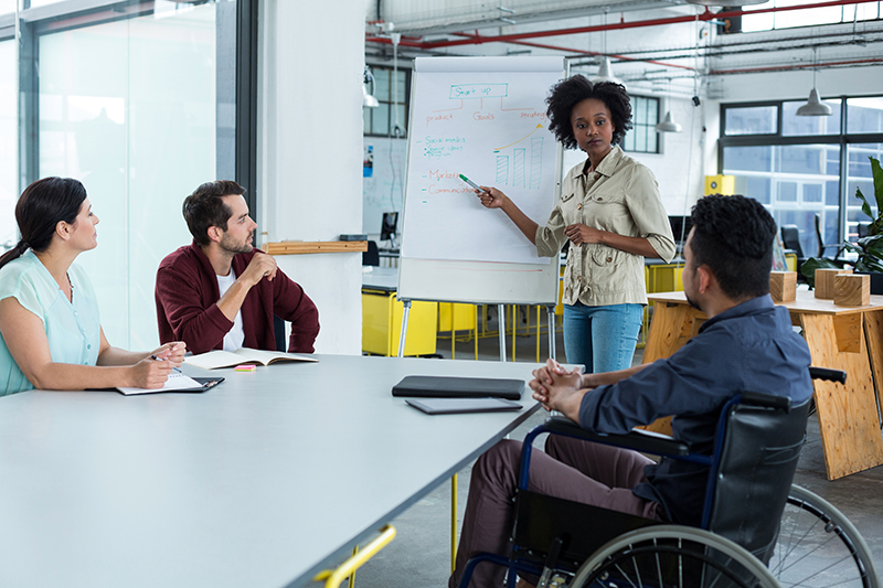 Business executives discussing over flip chart during meeting